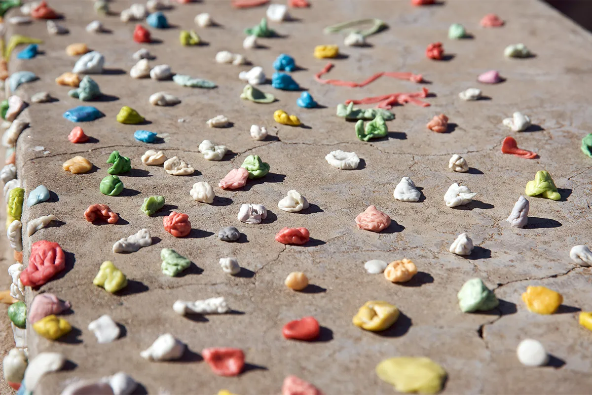 lots of different colours of chewing gum used and stuck on wall