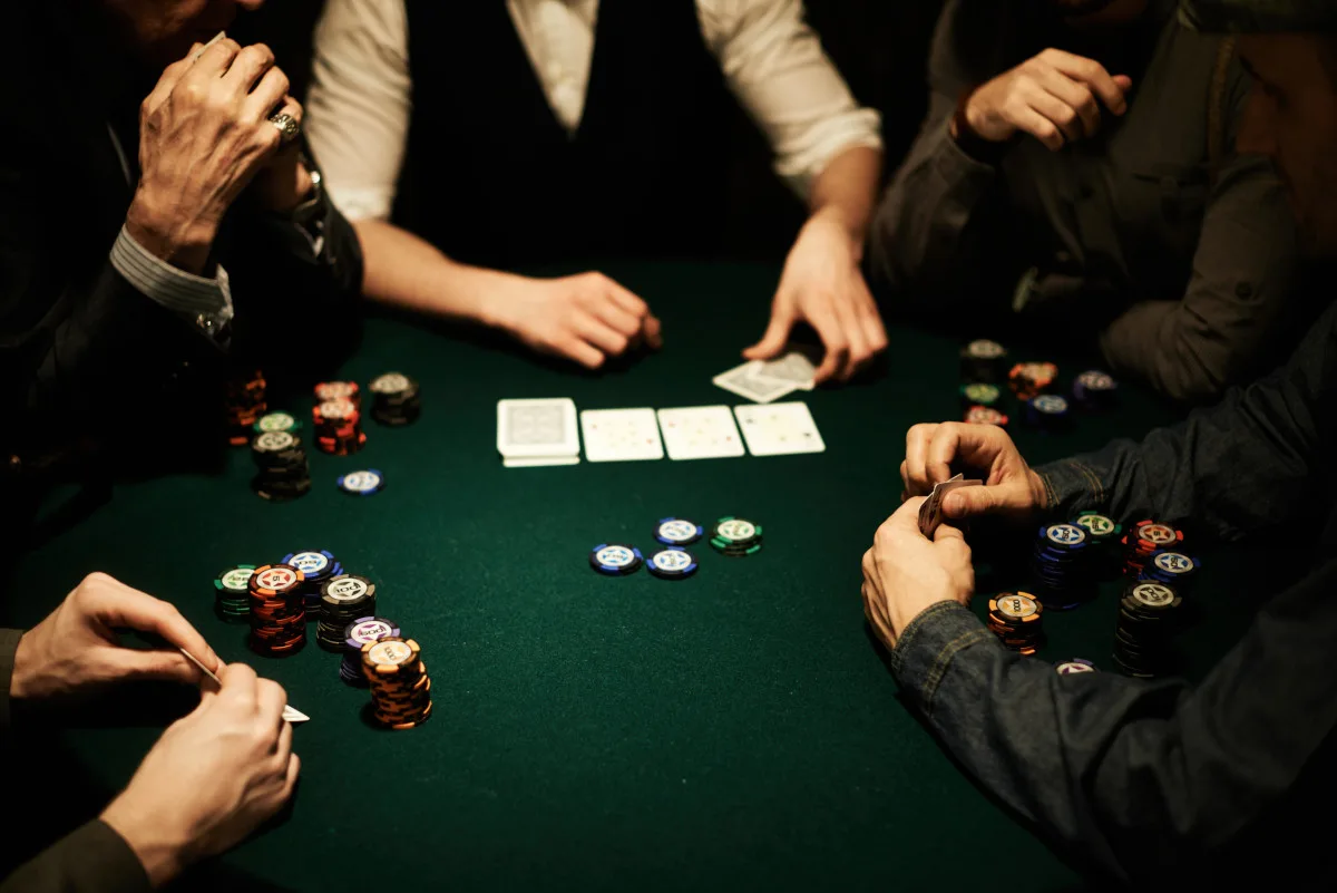 Players hands, stacks of gambling chips and cards on poker table