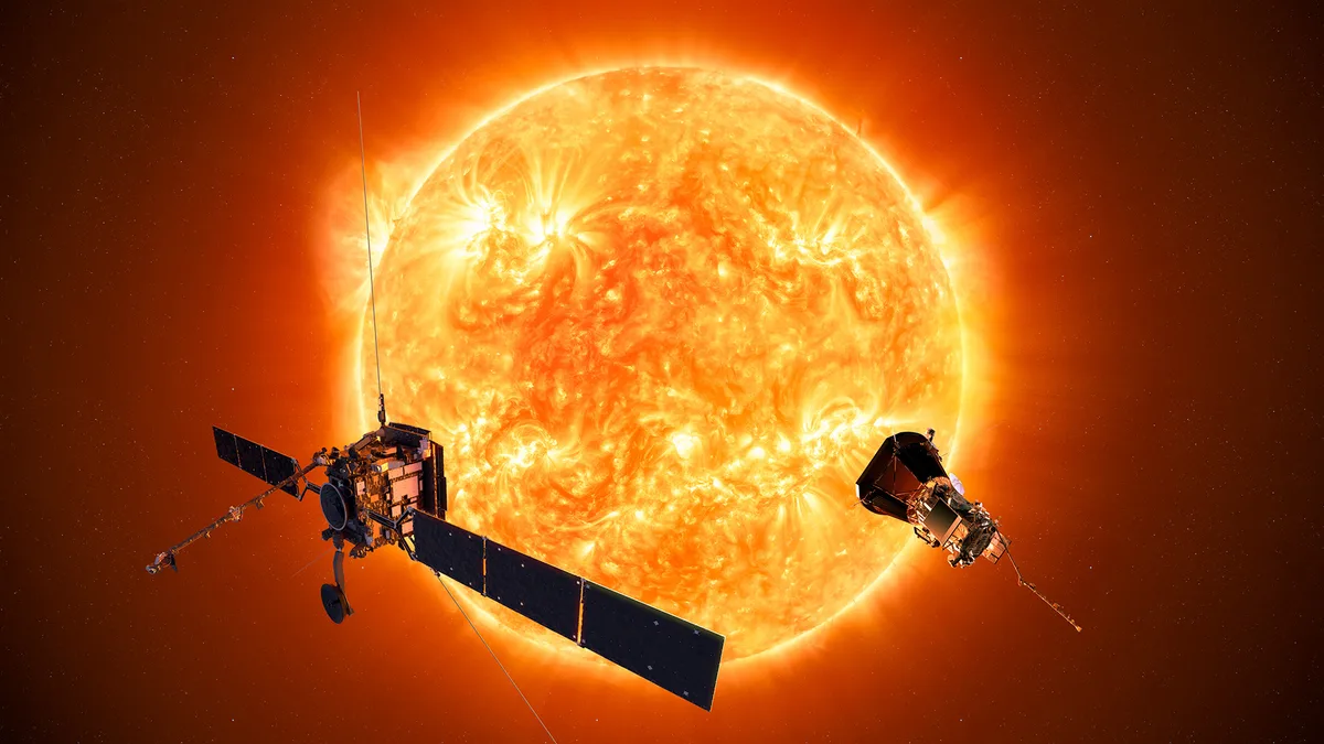 The Sun with two spacecraft floating in front of it